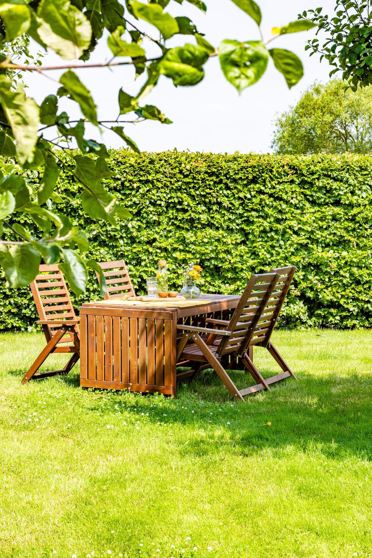 De tuintafel onder de fruitbomen naast de gastenstudio